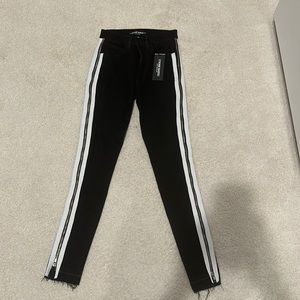 Etienne Marcel jeans. Black with white stripes and zippers down the side.